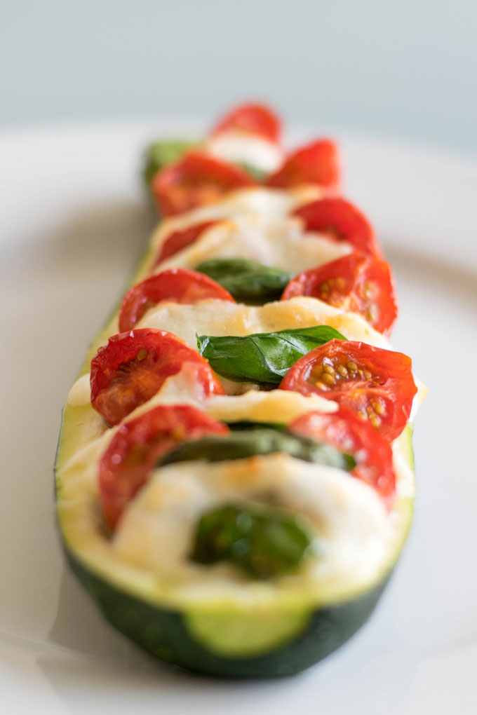 Gevulde courgette met tomaat, verse basilicum, pesto en mozzarella. Maak deze gevulde courgette in de oven & impress your friends! #courgette #gevuldecourgette #caprese | Anniepannie.nl