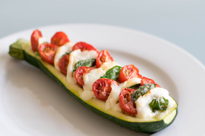 Gevulde courgette caprese uit de oven. Een gevulde courgette met tomaat, mozzarella, basilicum en pesto. #gevuldecourgette #courgette #caprese | Anniepannie.nl