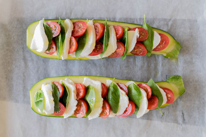 Gevulde courgettes uit de oven. Zo maak je gevulde courgette caprese met pesto, tomaat, mozzarella en verse basilicum. #courgette #saladecaprese #italiaans | Anniepannie.nl