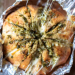 Kaasbrood met knoflookboter en kruiden ingepakt in aluminiumfolie