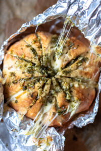 Kaasbrood met knoflookboter en kruiden ingepakt in aluminiumfolie