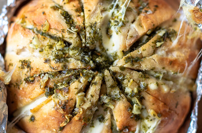 Kaasbrood met knoflookboter en kruiden ingepakt in aluminiumfolie