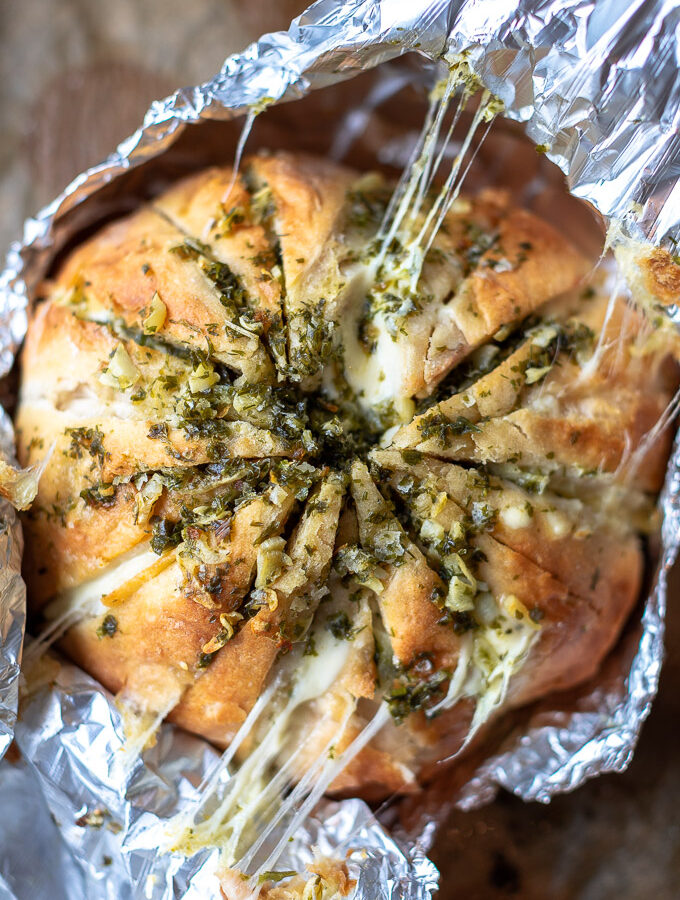 Kaasbrood met knoflookboter en kruiden ingepakt in aluminiumfolie